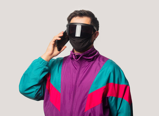 Styl chlap tvář maska a futuristické brýle s mobilním telefonem na bílém pozadí  - Fotografie, Obrázek