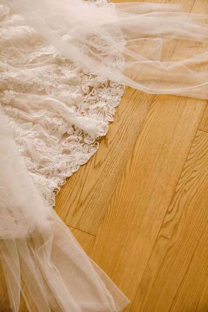 Vestido de novia de encaje de la novia en textura de madera de cerca. - Foto, Imagen