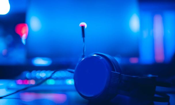 Profesionální sluchátka s mikrofonem pro videohry a kybernetické sporty na pozadí herního monitoru - Fotografie, Obrázek