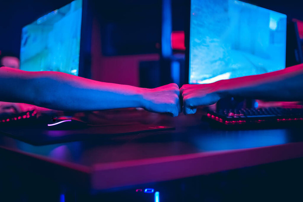Профессиональный геймер, играющий в онлайн игры турниры ПК компьютер с наушниками, размытый красный и синий фон - Фото, изображение