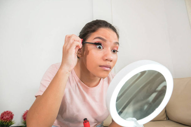 Junge schöne Frau trägt Mascara-Make-up auf Augen mit dem Pinsel auf - Foto, Bild
