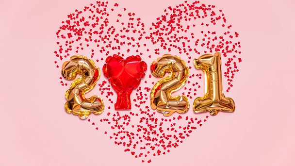 Happy New year 2021 celebration. Bright gold balloons figures, New Year Balloons with glitter stars on pink background. Christmas and new year celebration. Gold foil balloons 2021 gift card - 写真・画像