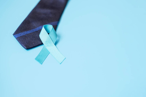 Listopad Rakovina prostaty Vědomost měsíc, lehká modrá stuha s kravatou na modrém pozadí pro podporu lidí žijících a nemocných. Men Healthcare, International men and World Cancday concept - Fotografie, Obrázek