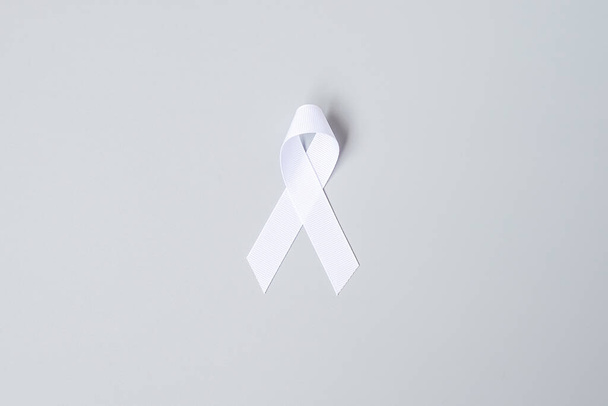 November Lungenkrebs-Aufklärungsmonat, Demokratie und internationaler Friedenstag. weiße Schleife auf grauem Hintergrund - Foto, Bild