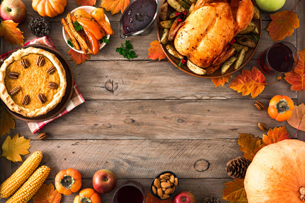 Thanksgiving dinner with chicken, cranberry sauce, pumpkin pie, wine, seasonal vegetables and fruits on wooden table, copy space. Traditional autumn holiday food concept. - Photo, image