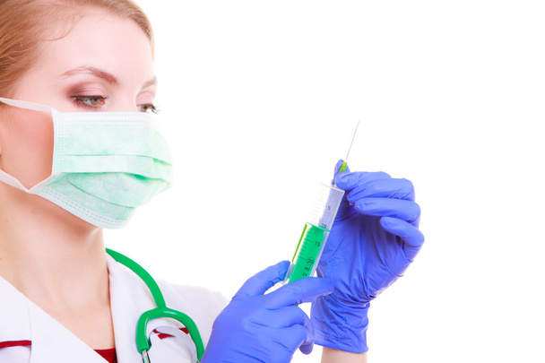 Woman in mask and lab coat. Doctor nurse with syringe. - Фото, изображение