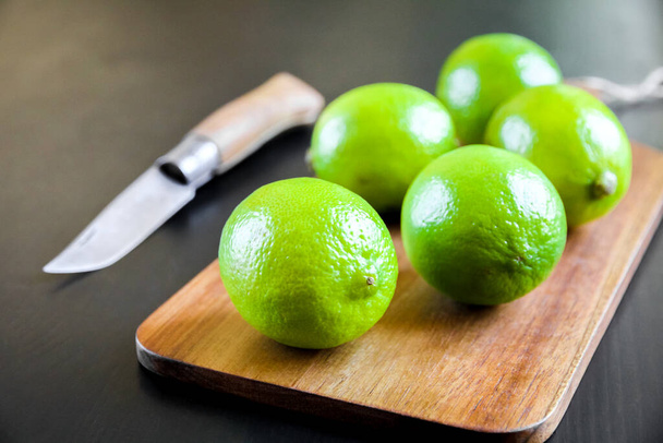 Lime and old traditional pocket knife on a wooden cutting board - Foto, Bild