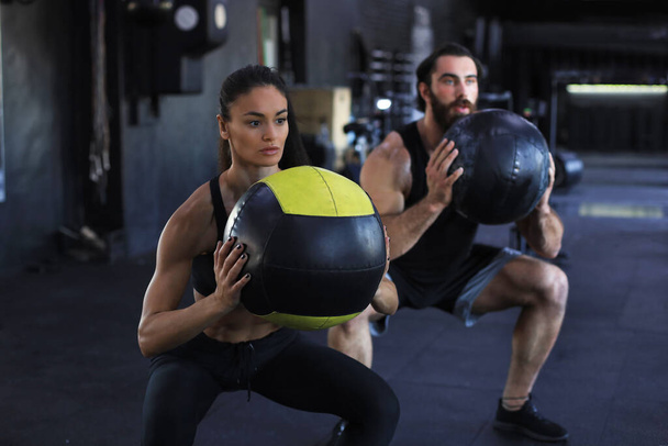 Attractive indian couple doing fitness with medcine ball at gym - Foto, Bild