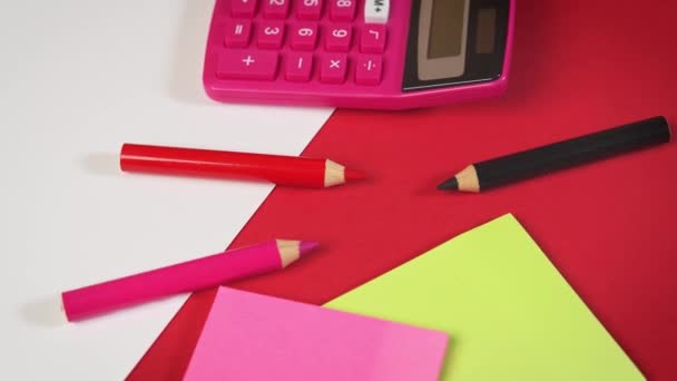 papel branco e calculadora e lápis de cor em uma mesa vermelha - Filmagem, Vídeo