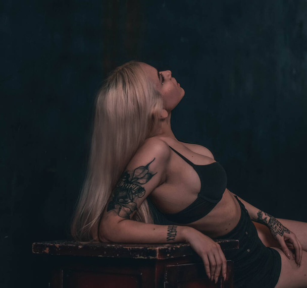 Fashion, sexy girl in a bra sits on a chair. Blonde - 写真・画像
