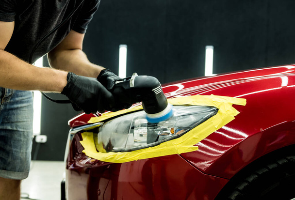 Car service worker polishes a car details with orbital polisher. - Valokuva, kuva