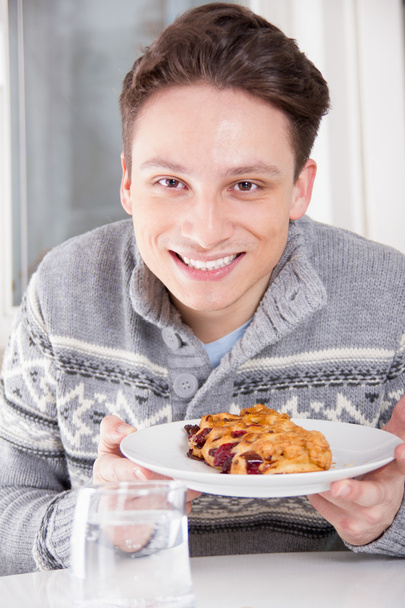 uomo sorridente che tiene il dessert sul piatto
 - Foto, immagini