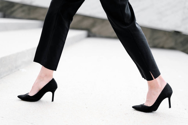 Şehirdeki merdivenleri tırmanan topuklu ayakkabı giyen bir iş kadını. Yavaş çekim. Bacaklarını yaklaştır.. - Fotoğraf, Görsel