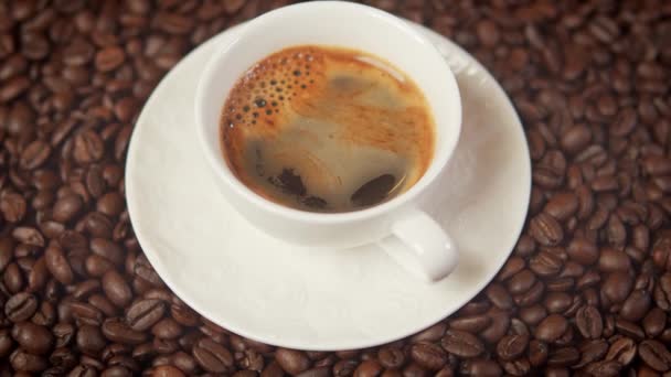  xícara de delicioso café quente e aromático cercado por sementes torradas - Filmagem, Vídeo