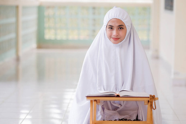 Młoda muzułmanka czytająca Koran w meczecie - Zdjęcie, obraz