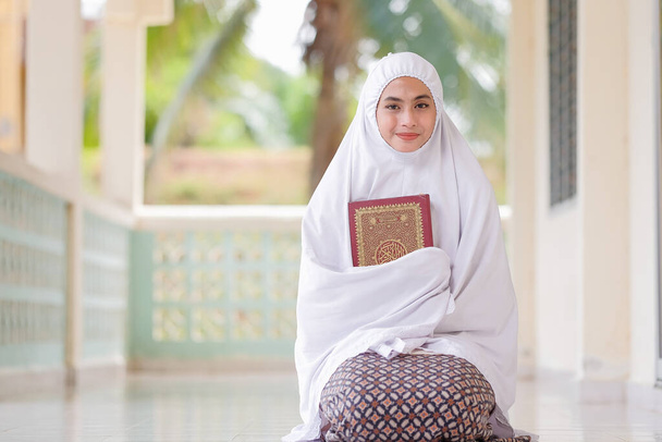 Muzułmańskie kobiety trzymają Koran w meczecie na modlitwę. - Zdjęcie, obraz