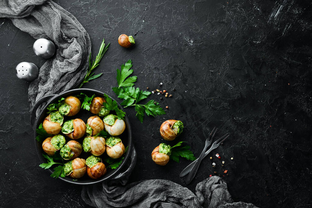 "Escargots de Bourgogne" - baked snails with garlic, butter and basil. French traditional food. Top view. Free space for your text. - Foto, Bild