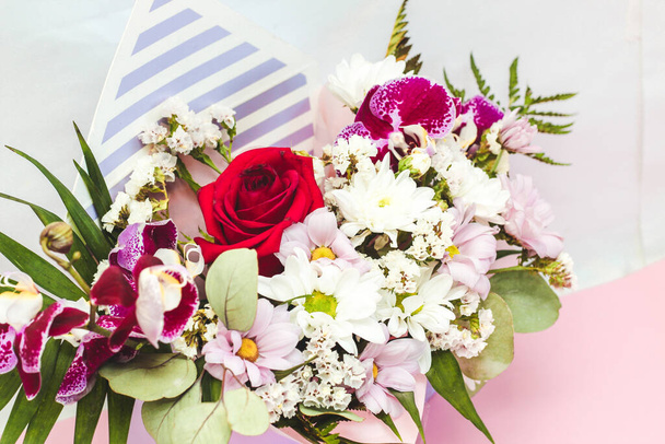 Pudełko w formie koperty z bukietem kwiatów. Orchidee, zieleń, chryzantemy i róże. - Zdjęcie, obraz