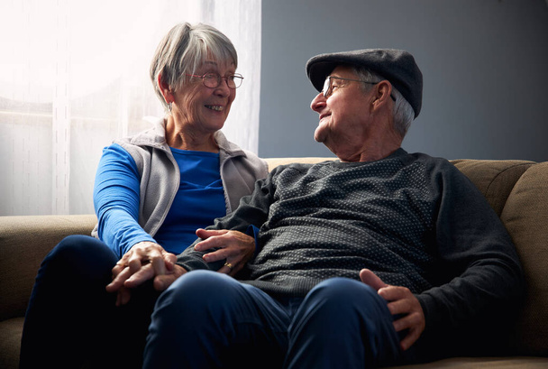 Amando casal sênior sentado no sofá em casa juntos - Foto, Imagem