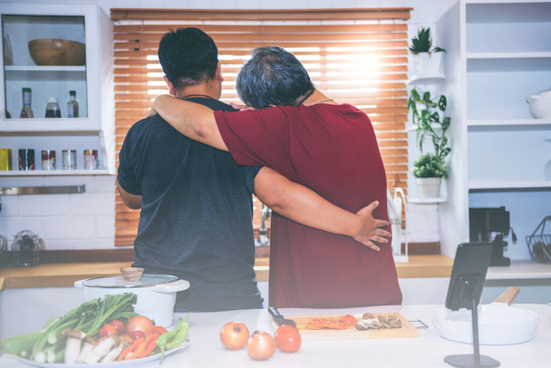 Az alternatív szexpárok vagy az LMBT ázsiai férfi háta, jelenleg együtt élvezik a tevékenységeket azáltal, hogy főznek a konyhában, az embereknek és az LMBT koncepció. - Fotó, kép