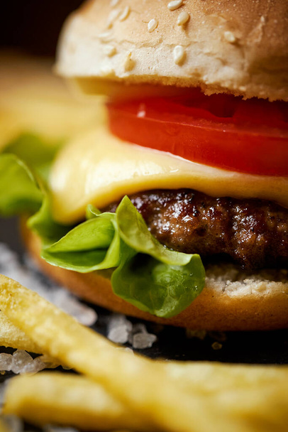 finom sajtburger egy fekete asztalon, sós kristályokkal - Fotó, kép