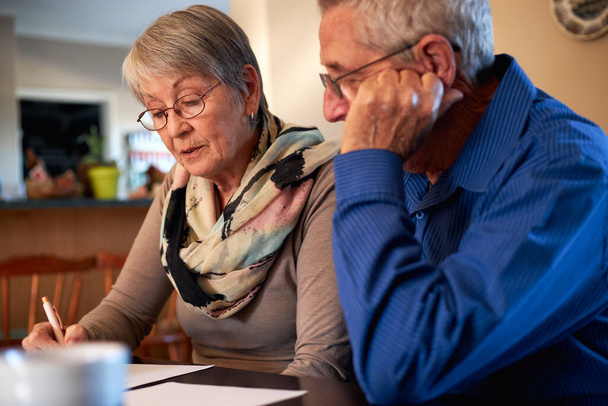 Starší pár sedí doma u stolu a kontroluje osobní finance - Fotografie, Obrázek