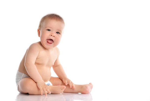 Adorable baby sitting and looking aside over white background - Foto, Imagem