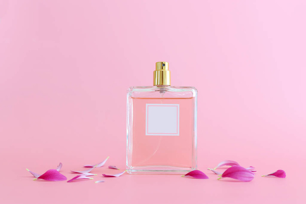 Image of elegant perfume bottle over pink pastel background - Фото, зображення