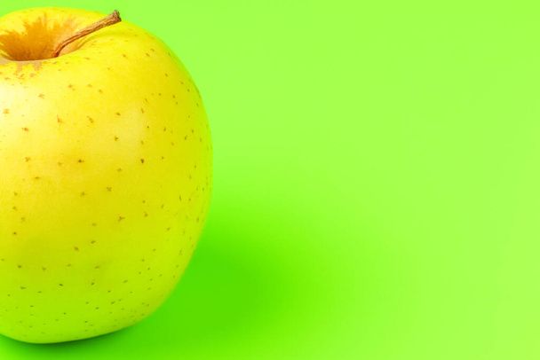 manzana amarilla sobre un fondo verde close-up.isolate - Foto, Imagen