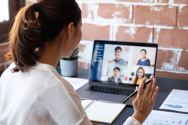 Jonge Aziatische zakenvrouw werk thuis en virtuele video conferentie vergadering met collega 's zakenmensen, online werken, video-oproep als gevolg van sociale afstand in het thuiskantoor - Foto, afbeelding
