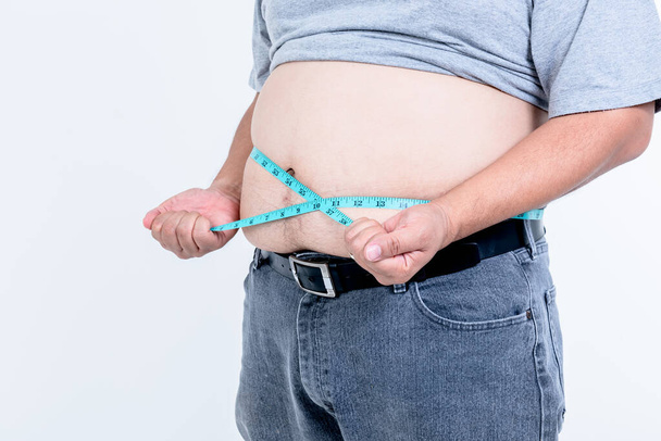 Zbliżenie zdjęcia otyłych mężczyzn użyć miarki taśmy przymocuj jego brzuch tłuszczu Na białym tle, do grubasa człowieka i opieki zdrowotnej koncepcji. - Zdjęcie, obraz