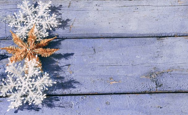 Gyönyörű lila karácsonyi vízszintes háttér fehér hópelyhek és arany fényes csillag. Fából készült karácsonyi háttér, felülnézet. A szöveg helye az új év hátterében. - Fotó, kép