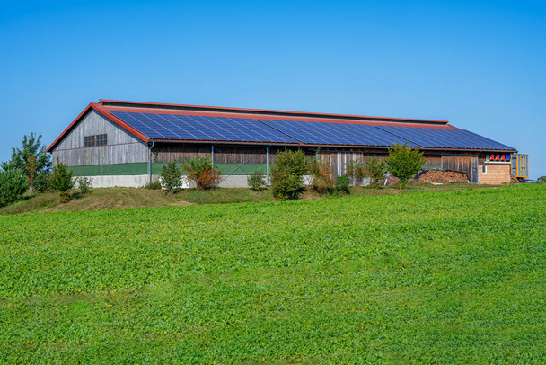 Πράσινη ενέργεια με ηλιακούς συλλέκτες στην οροφή ενός γεωργικού κτιρίου - Φωτογραφία, εικόνα