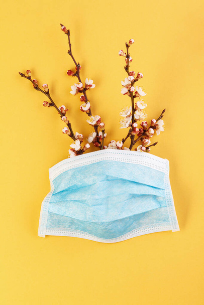 The concept of comparing prevention and health with spring in nature. Means of preventing viral diseases. Medical mask gloves on a yellow background.  Corona virus. - Photo, Image