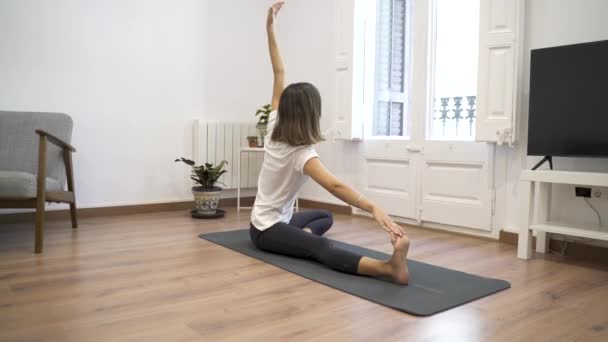 Young girl doing yoga in her living room. - Video, Çekim