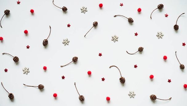 Pattern of cones, white snowflakes, red balls and stars on a white background, top view, flat lay, copy space.Christmas and New Year background and greeting card concept. - Φωτογραφία, εικόνα