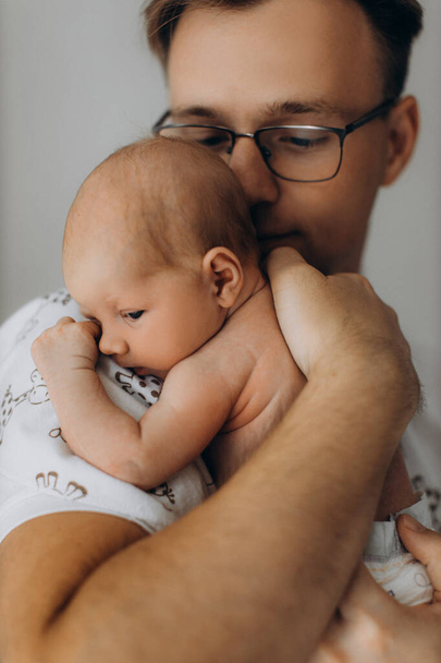 Handsome man hold adorable newborn baby girl in arms, caring dad look with love at the little daughter, enjoy tender parenting moments, fatherhood concept - Foto, imagen