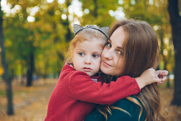 мати-дочка обожнює обійматися на осінньому міському парку осінній сезон
 - Фото, зображення