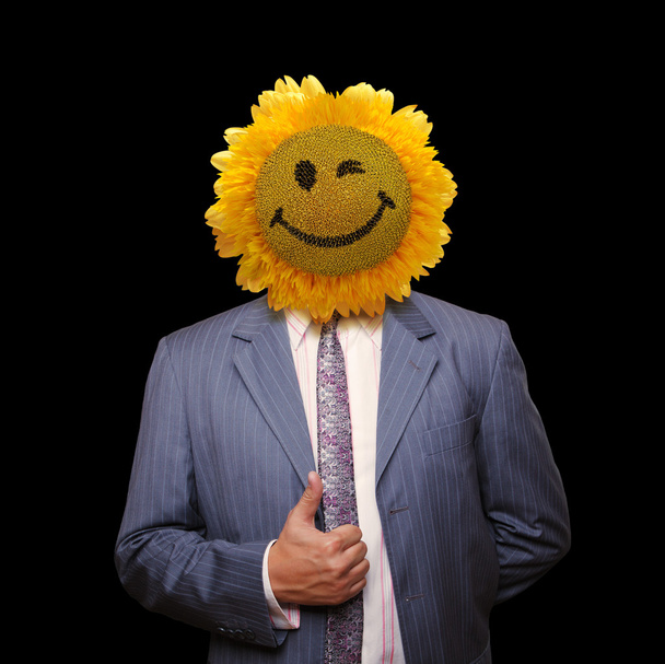 Smiling sunflower head man in suit coat with present thumbs up o - Фото, изображение
