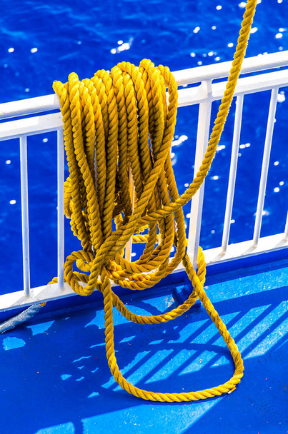 Fechar a corda amarela trançada sobre um corrimão de navio - Foto, Imagem