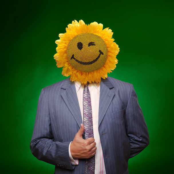 Smiling sunflower head man in suit coat with present thumbs up o - Photo, Image