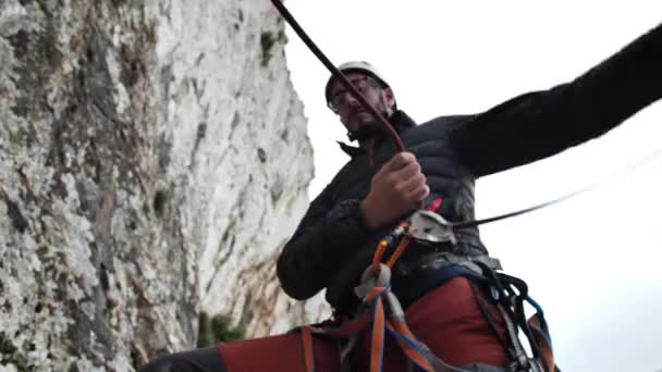 Muž získává lano, zatímco oddaluje svého lezeckého partnera v Betlemu, Mallorce, Španělsku.Vysoký úhel, paralaxní pohyb, 4K 60p. - Záběry, video