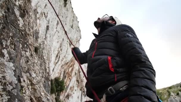 Uomo che dà corda durante l'assicurazione del suo compagno di arrampicata a Betlem, Maiorca, Spagna.Angolo alto, movimento a parallasse, 4K 60p. - Filmati, video