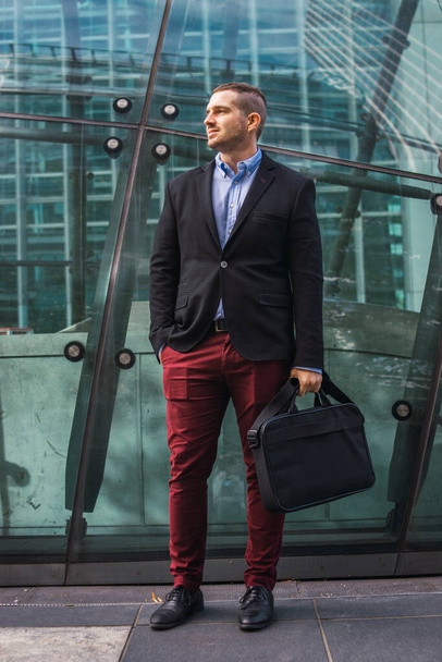 Photo of a young and attractive business man wearing smart clothes with a briefcase ready to start his work day - Photo, image