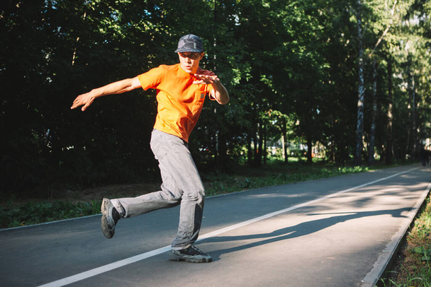 Young guy dancing on the road in the park in summertime - Foto, immagini