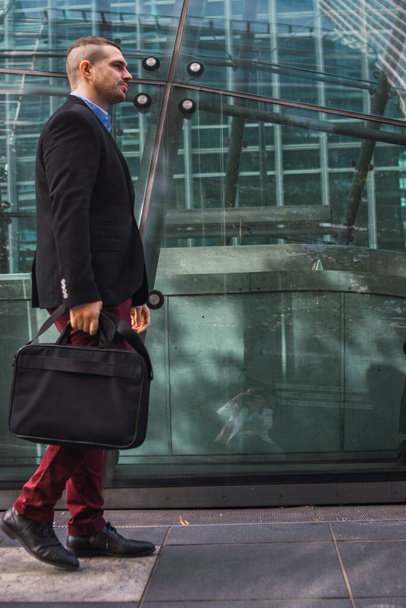 Photo of a young and attractive business man wearing smart clothes with a briefcase ready to start his work day - Photo, Image