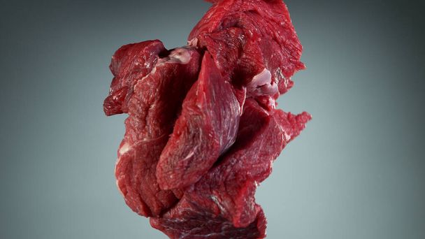 Raw beef steaks flying up in the air, isolated on grey background - Fotografie, Obrázek