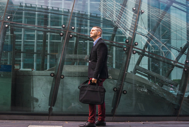 Photo of a young and attractive business man wearing smart clothes with a briefcase ready to start his work day - Фото, изображение