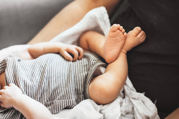 Close up photo of babys feet lying on his father while trying to sleep in a sunny day - Φωτογραφία, εικόνα