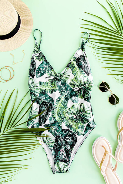 Womans beach accessories: bikini, rattan bag, straw hat, tropical palm leaves on yellow background. Summer background.  - Zdjęcie, obraz